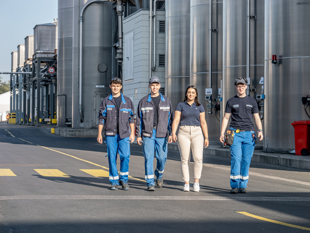 Auszubildende auf Werksgelände vor Silos